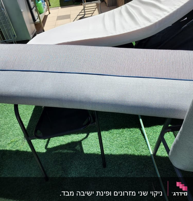 כריות ספה אפורות מונחות לייבוש על שולחן בחוץ